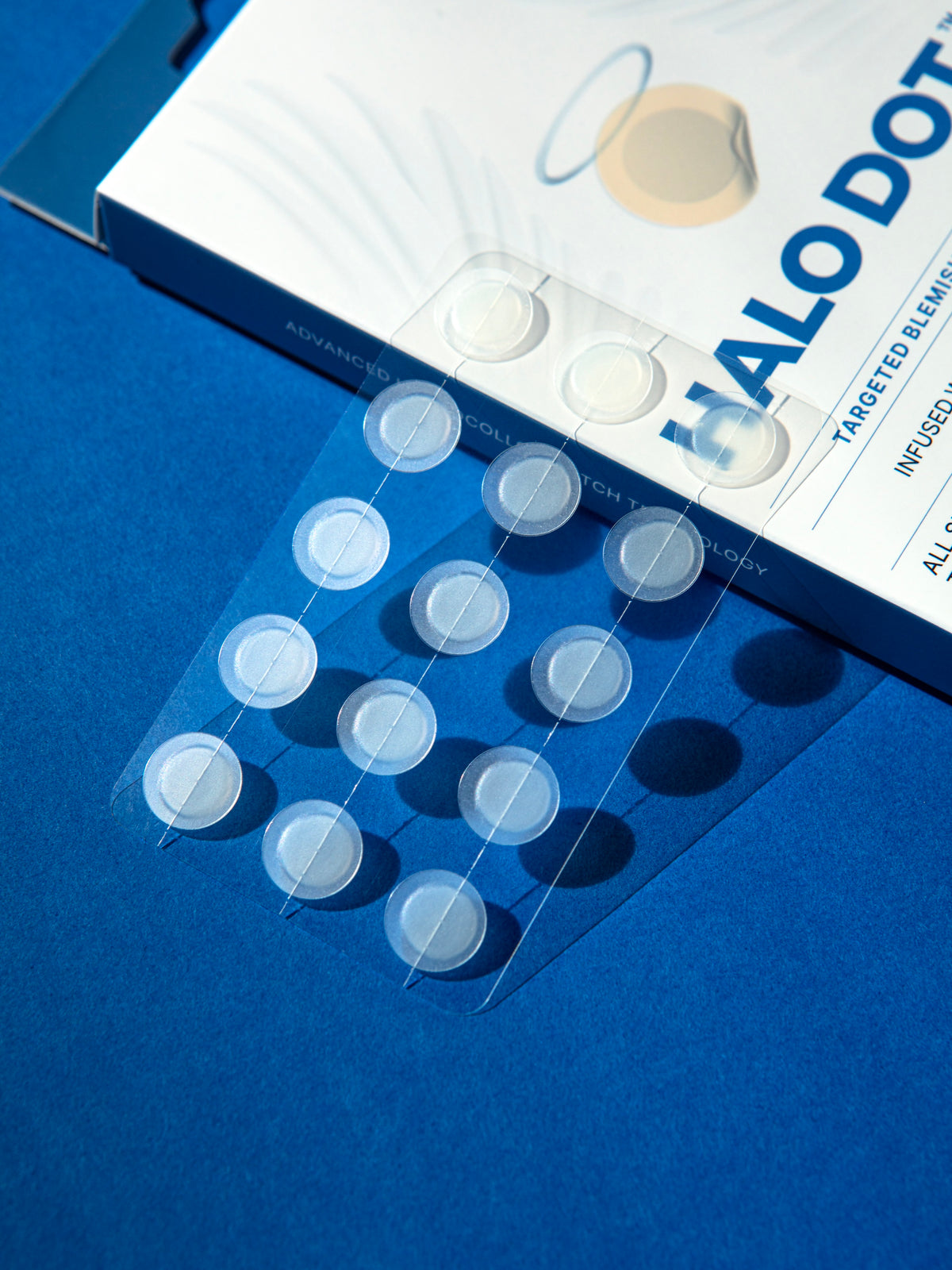 Close-up of clear Halo Dot hydrocolloid patch strips beside the package